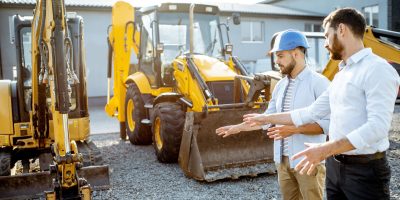 Two-home-service-providers-looking-at-and-discussing-their-excavators